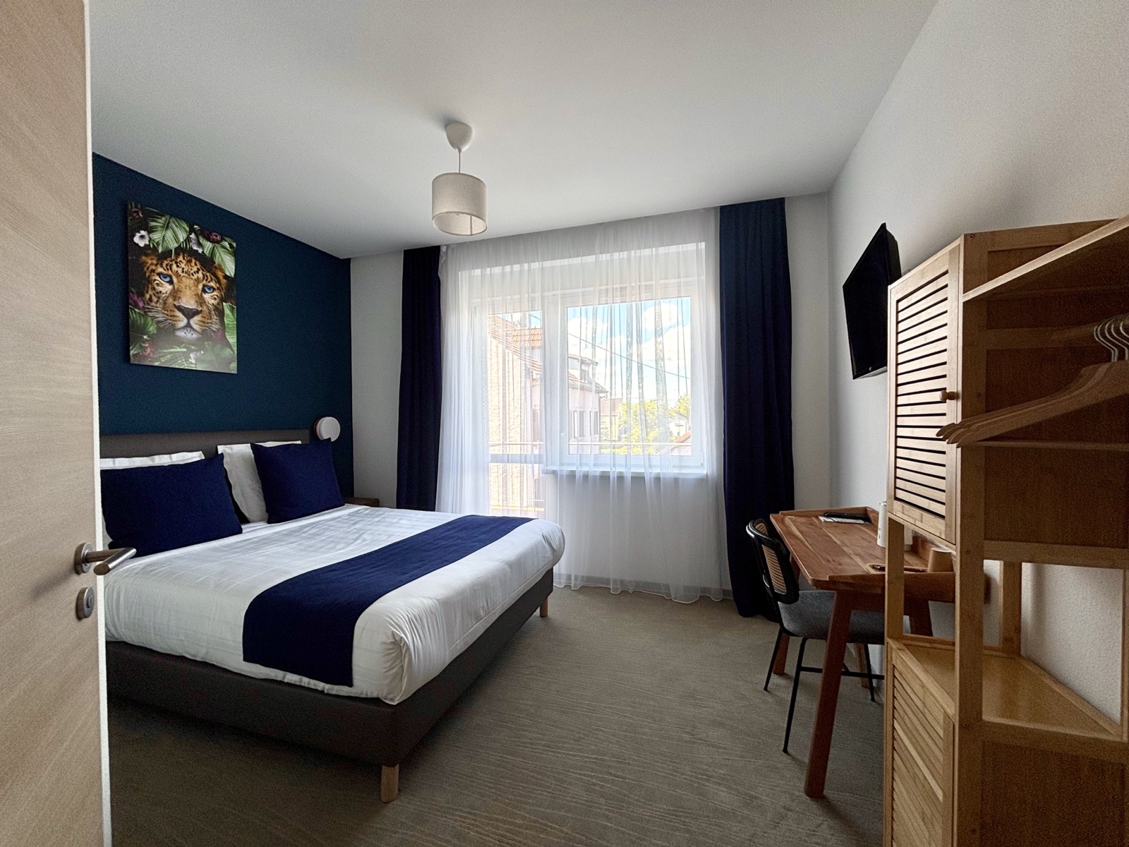 Chambre double supérieure — mur bleu nuit, tableau léopard